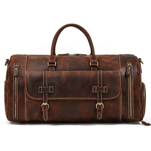 Detailed view of vintage brown leather travel bag with bronze hardware and multiple pockets