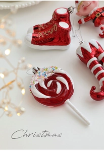 Detailed view of red and white glittered Christmas ornaments featuring elf shoes and lollipops