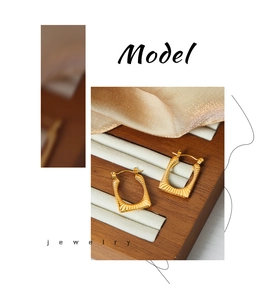 Detail shot of vintage square gold earrings featuring a sunburst texture and latch closure