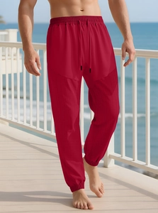 Detail of dark red drawstring sweatpants with waffle texture and elastic ribbed cuffs