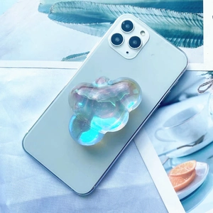 Close-up of a holographic bear phone grip with glitter on a light green smartphone