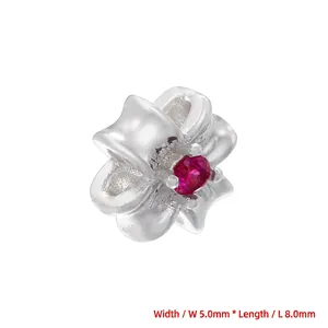 Macro detail of silver-plated flower bead with red zircon inlay measuring 5x8mm