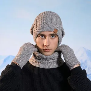 Three-piece winter knit set including grey cable knit beanie, scarf, and gloves for outdoors