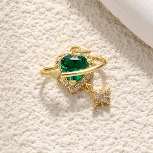 Macro shot of 18K gold leopard heart pendant with green gemstone and star charm