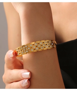Detail of 18k gold plated hollow lattice bangle with star patterns and inlaid zircons