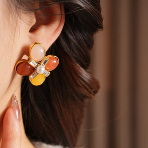 Gros plan détaillé de boucles d'oreilles vintage avec pierres colorées et centre en perle