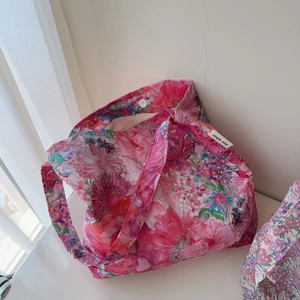 Detail of floral canvas tote bag showing the magnetic snap closure and woven logo tag