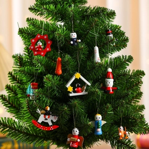 Close-up of hand-painted wooden Christmas tree ornaments hanging on green branches