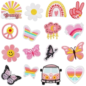 Close-up of retro hippie embroidery patches including rainbow, butterfly and van shapes