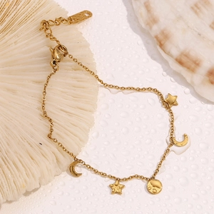 Gold star and moon pendant bracelet with lobster clasp on a beach-style background