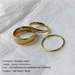 Three minimalist gold stainless steel rings in 1mm 3mm and 6mm widths displayed on paper