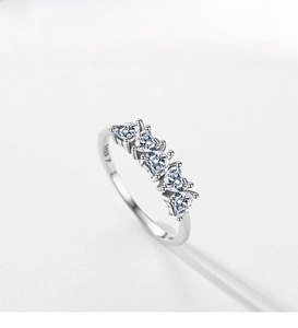 Macro detail showing the S925 hallmark and heart-cut zirconias on the silver ring