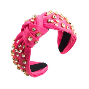 Detail of bright pink knotted headband featuring sparkling rhinestones on ribbed fabric