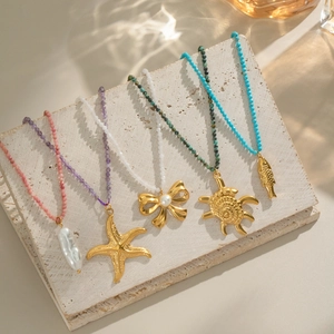 Ocean-themed beaded necklaces with starfish and turtle pendants on stone surface