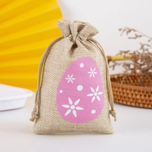 Detail view of burlap Easter drawstring bag with pink egg pattern and floral accents
