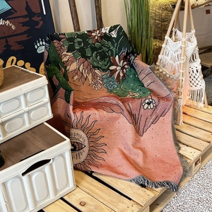 Detail of bohemian woven camping blanket with cactus pattern and decorative fringe edges