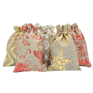 Five burlap Christmas gift bags with gold foil snowflakes and trees on white background