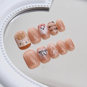 Cute pink cat-eye press-on nails with bear and bow designs on a pearl mirror base