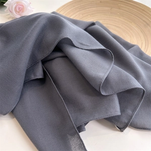 Detailed view of grey crinkled cotton linen scarf with soft texture and natural drapes