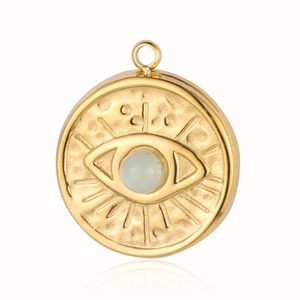 Close-up of golden evil eye pendant with light blue gemstone and sunburst texture