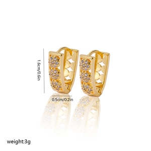 Macro shot of V-shaped gold earrings with zircon pave and hollow heart patterns