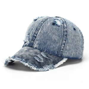 Close-up of distressed vintage blue washed denim baseball cap with frayed hole details