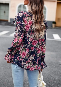 Rear view of a navy blue floral blouse with ruffles and long sleeves on a model