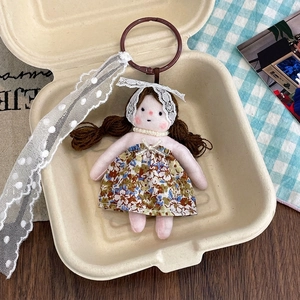 Detail of floral dress doll pendant with lace ribbon and pearl necklace in gift box