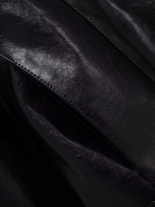 Close-up of premium black leather jacket showing natural texture and fine stitching