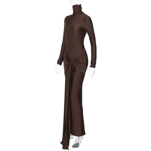 Détail d'une robe moulante marron à col montant avec nœud à la taille et ourlet irrégulier