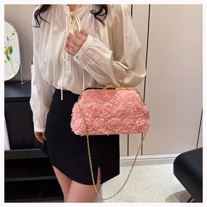 Close-up of pink evening bag with 3D floral roses and diamond encrusted spherical clasp