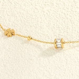 Élégant collier trèfle doré avec zircons étincelants et perles sur une chaîne fine