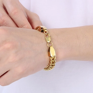 Men's bold golden stainless steel cuban curb chain bracelet shown on wrist
