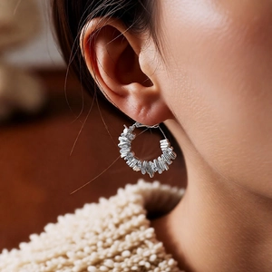 Gros plan de boucles d'oreilles géométriques en argent avec cristaux sur un mannequin