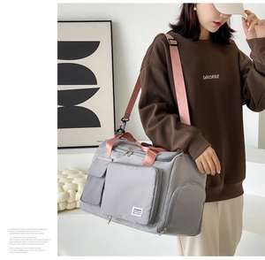 Grey fitness travel bag with pink straps showing spacious dual-use shoulder strap design