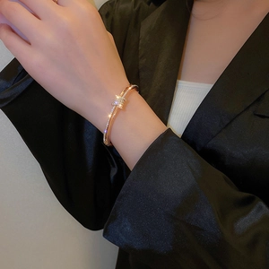 Detailed close-up of a luxury gold star bangle with sparkling zircons on a model's wrist