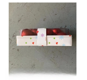 Detail of red Christmas ball ornament set in decorative packaging with festive star patterns