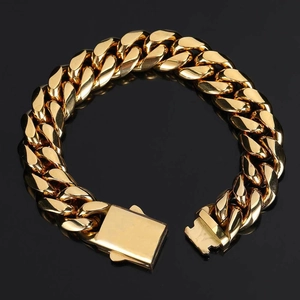 Détail d'un bracelet gourmette dorée polie avec fermoir carré sur surface noire
