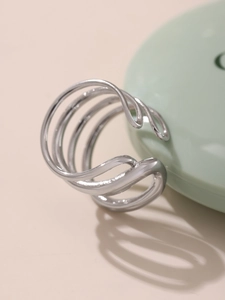 Detailed close-up of layered silver streamlined open ring with polished metallic finish