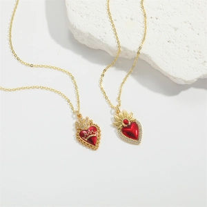 Chic golden angel heart pendant necklace set with red enamel on a white stone background