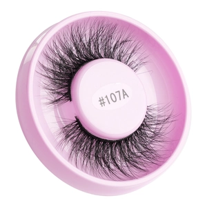 Detail of voluminous black false eyelashes #107A in a pink circular storage case