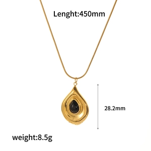Macro shot of gold teardrop necklace pendant with black stone and detailed measurements