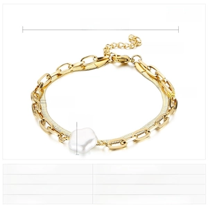 Detailed view of baroque shell charm on a gold snake chain and stainless steel links