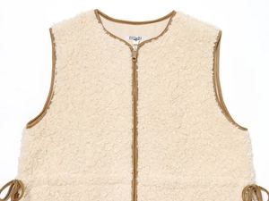 Detail view of beige sherpa fleece vest with brown trim and gold zipper hardware