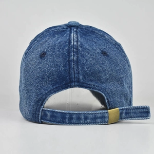 Detail of washed blue denim baseball cap showing rear metal buckle and 6-panel stitching