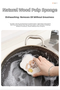 Detailed view of cloud-shaped wood pulp sponge cleaning a pan with rich foam
