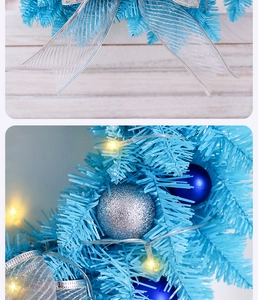 Detail of blue Christmas wreath with silver bows, baubles and warm LED fairy lights