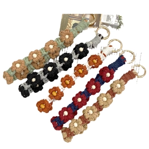 Handmade woven daisy flower keychains with wooden beads and gold metal rings in five colors