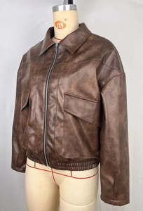 Dettaglio della giacca bomber in pelle marrone con revers e orlo elasticizzato