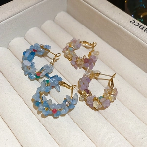 Detail view of blue and purple natural stone beaded hoop earrings on a velvet display tray